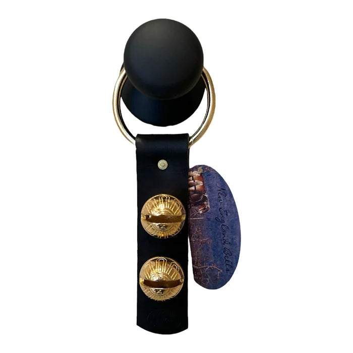 Black leather keychain with gold accents and a purple stone on a white background