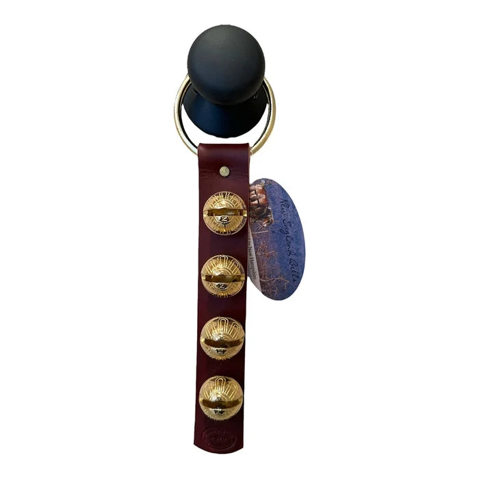 Black object with gold buttons and a leather strap on a white background