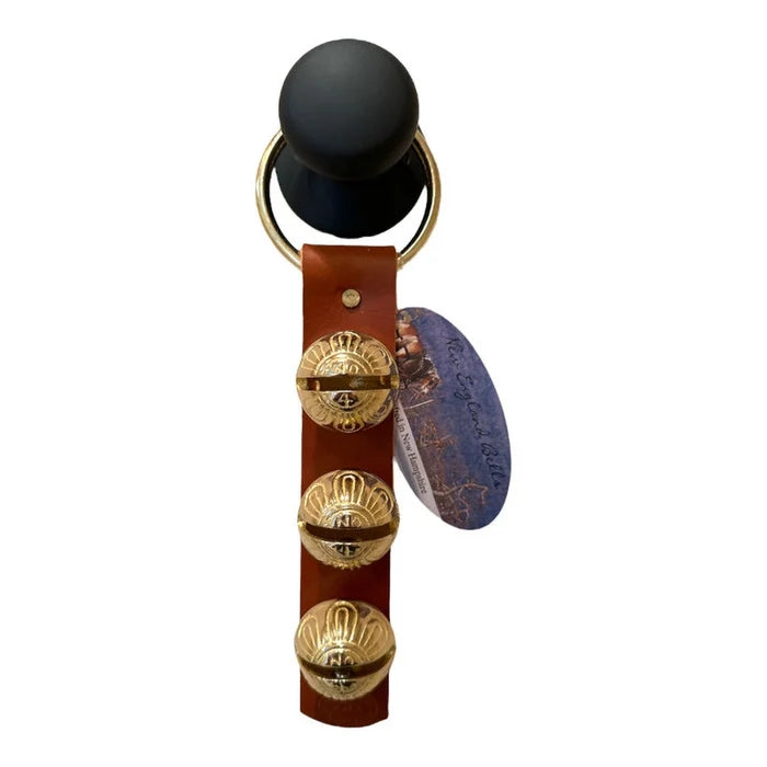 Keychain with leather strap, gold accents, and black ball on a white background