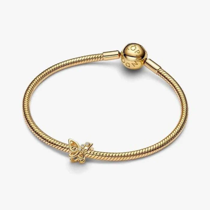 Golden butterfly-shaped charm on a light background