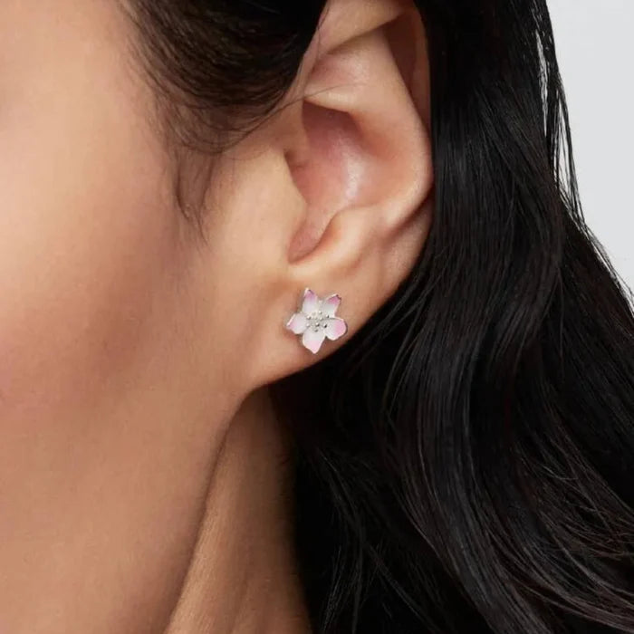 Close-up of a woman's wearing a floral earring with a neutral background