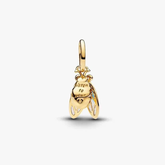 Gold cicada-shaped charm on a light background
