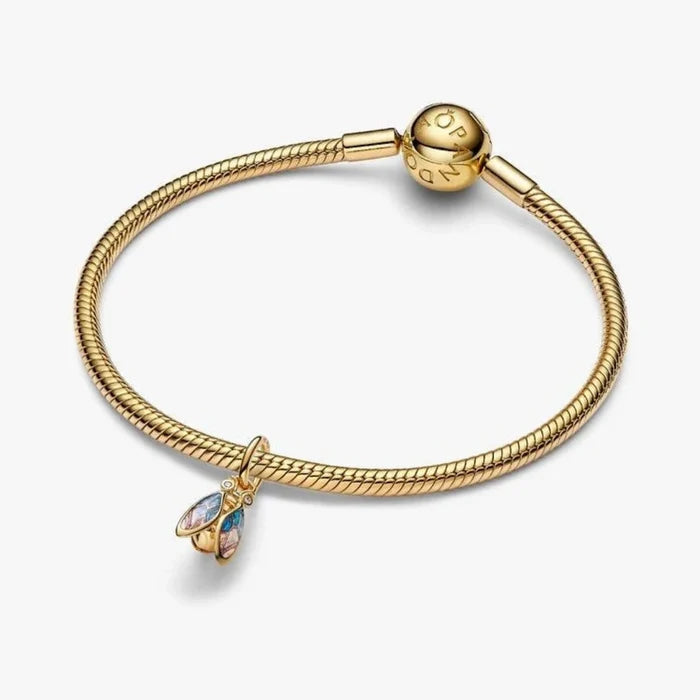 Gold cicada-shaped charm on a light background
