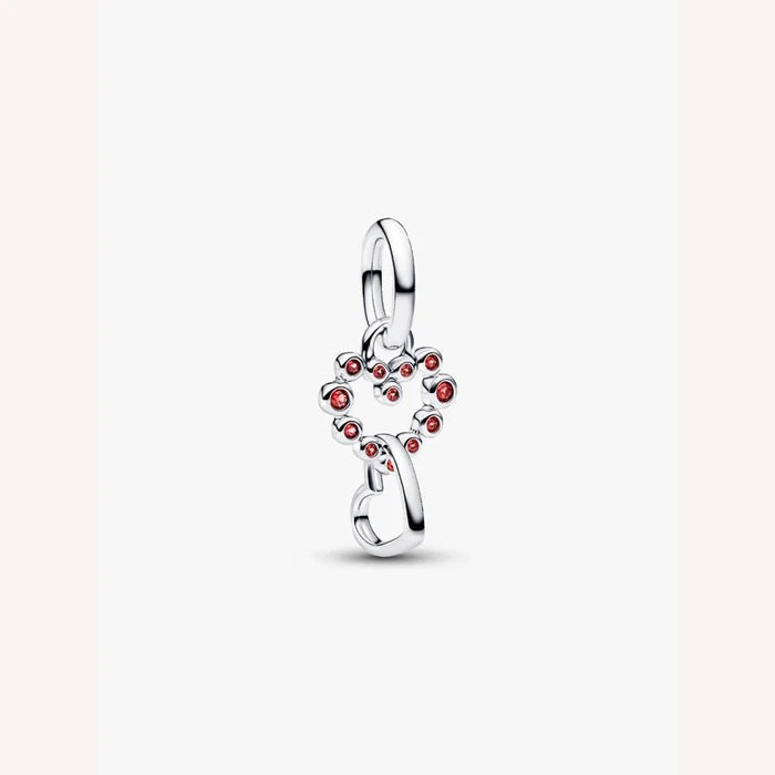 Silver heart with red gemstones on a light background