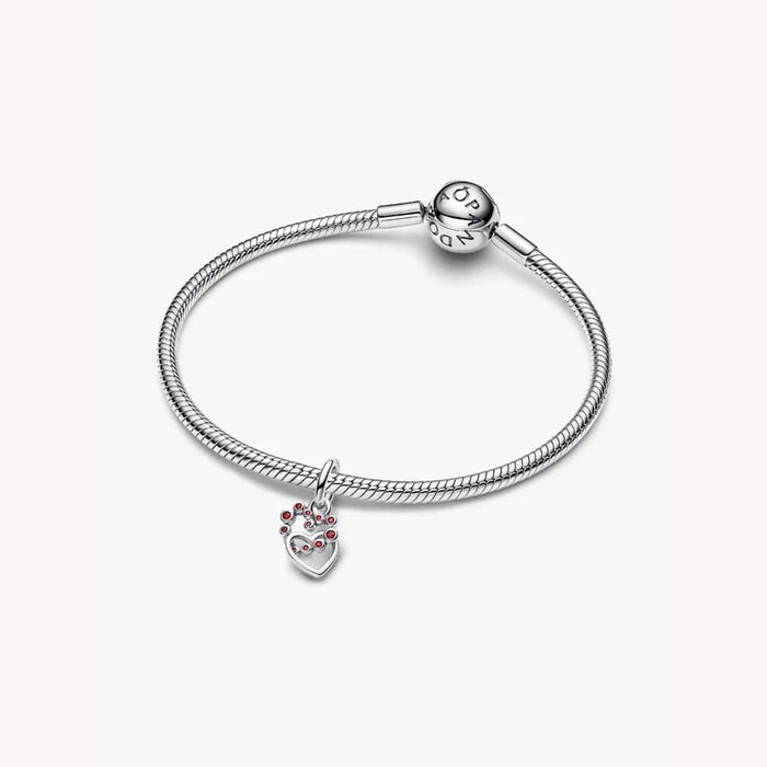 Silver bracelet with a heart-shaped charm on a light background