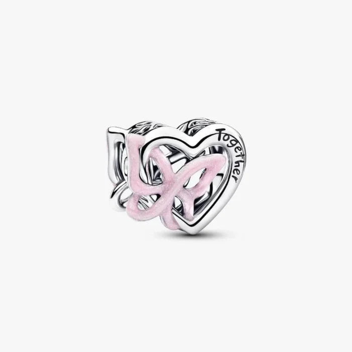 Silver heart and butterfly shaped charm on a light background