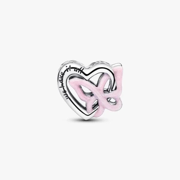 Silver heart and butterfly shaped charm on a light background