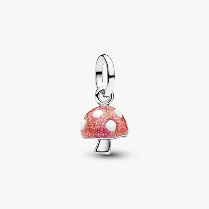 Mushroom-shaped charm with red and white polka dot design on a white background