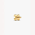 Gold puzzle piece charm on a light background
