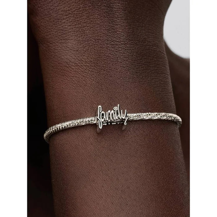 Pandora Handwritten Family Charm worn on wrist, styled on a silver bracelet.