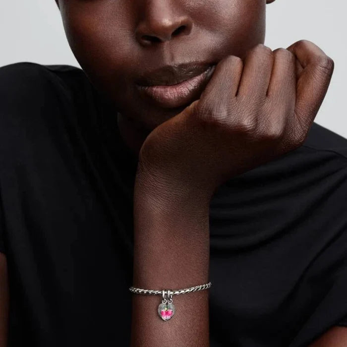 Silver bracelet with a bird-shaped charm on the wrist of a women