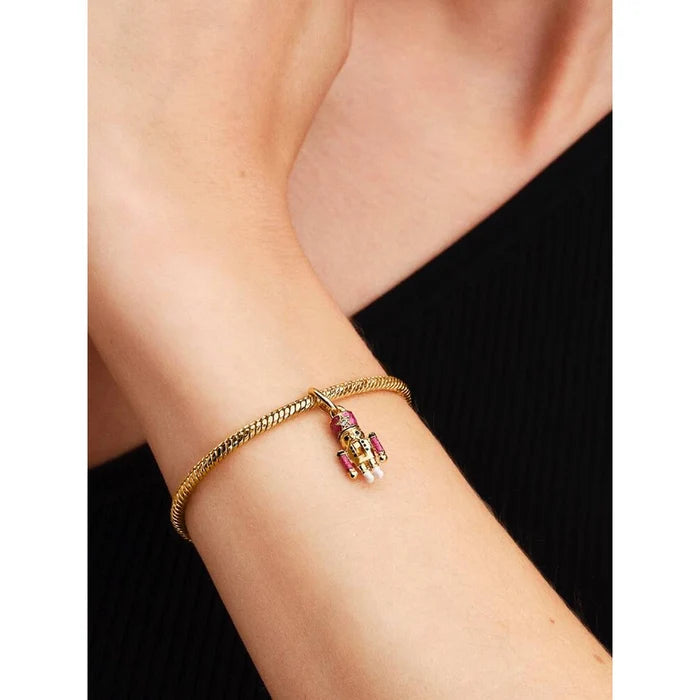 Model wearing a gold Pandora bracelet with the Moveable Nutcracker Dangle Charm.