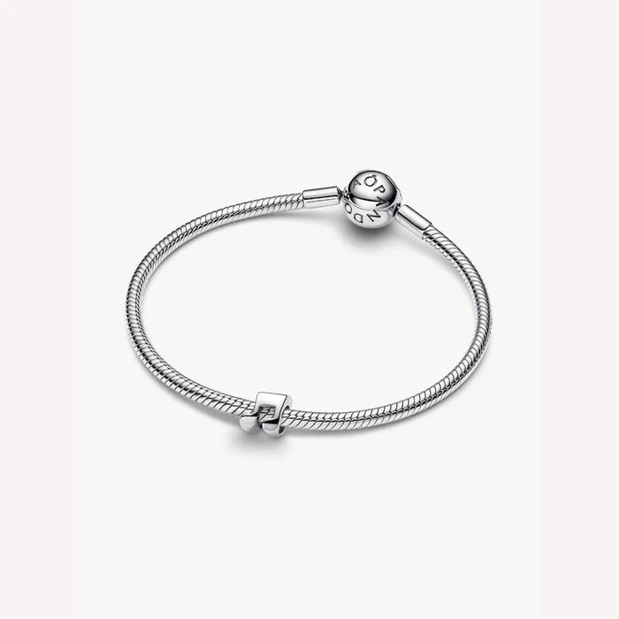 Silver bracelet with a mini music note charm on a light background