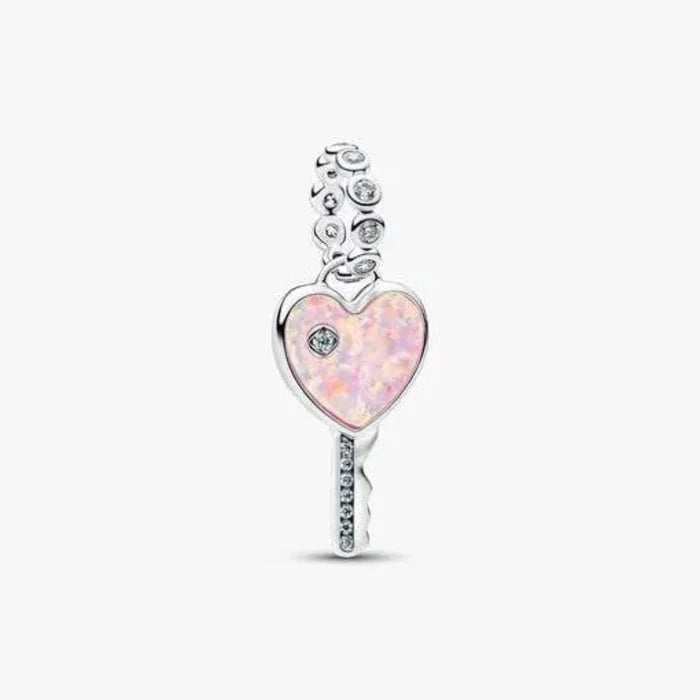 Heart-shaped key charm with pink opal and clear gemstones on a white background