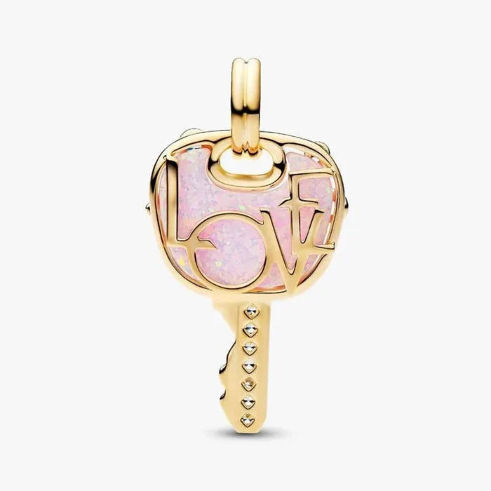 Gold pendant with pink heart design on a white background
