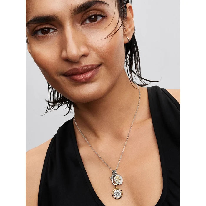 Woman wearing Pandora silver oval link necklace with attached coin charms for a personalized look.