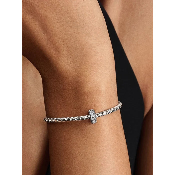 Pandora Pavé Clip Charm worn on a bracelet, shown on a model’s wrist.