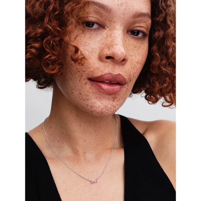 Model wearing PANDORA Pink Bow Necklace showcasing dainty silver chain and pink gemstone bow.