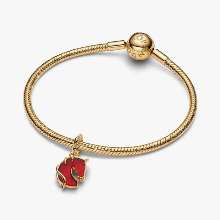 Gold bracelet with a red horse charm on a white background