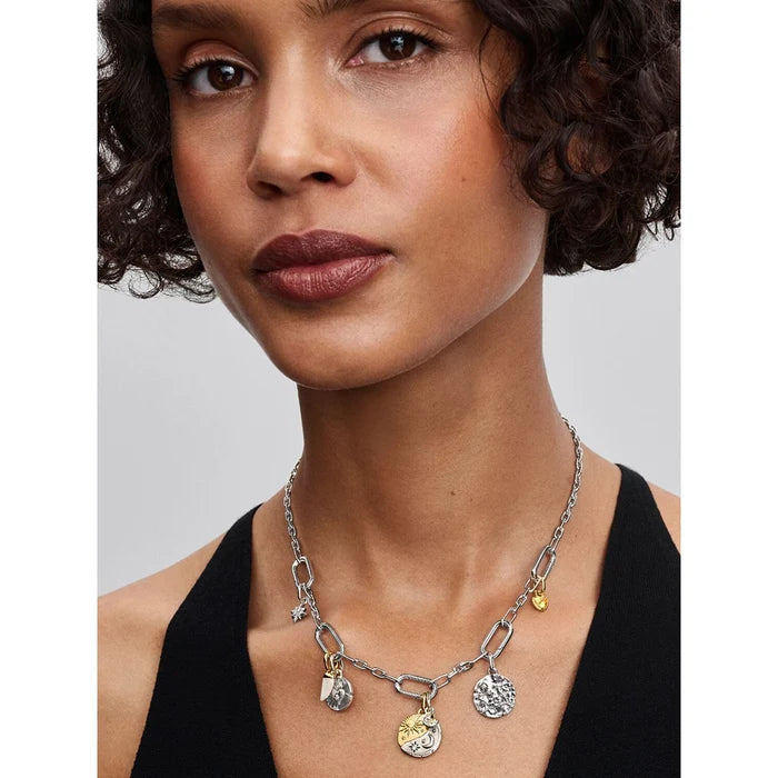 Woman wearing Pandora celestial necklace with mixed metal coin charms in gold and silver.