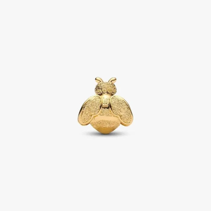 Gold bee-shaped charm on a white background