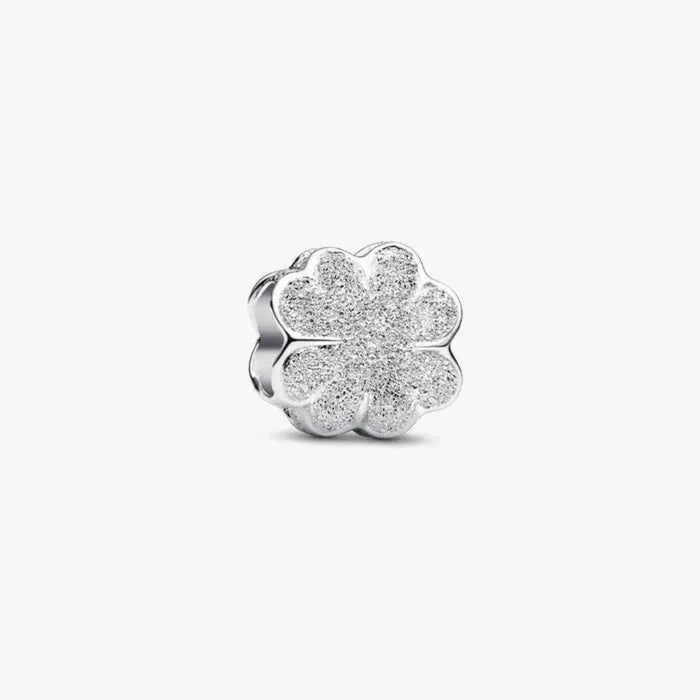 Silver four-leaf clover charm on a white background