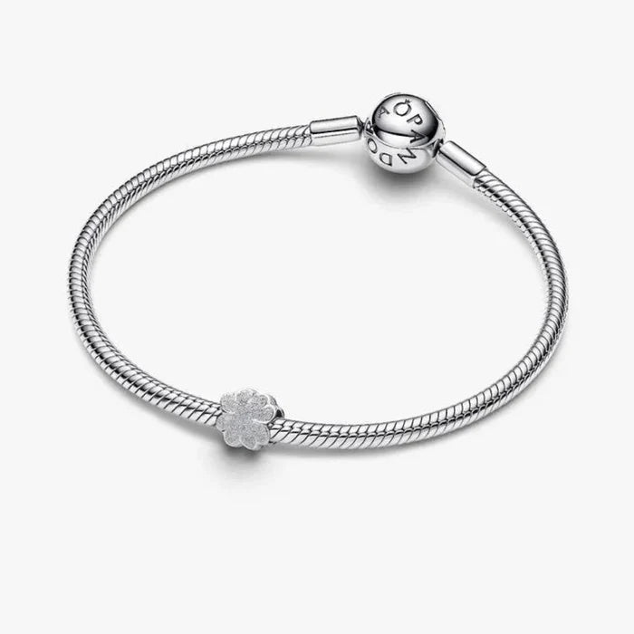 Silver bracelet with a textured charm on a white background