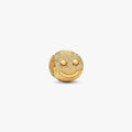 Gold smiley face charm on a white background