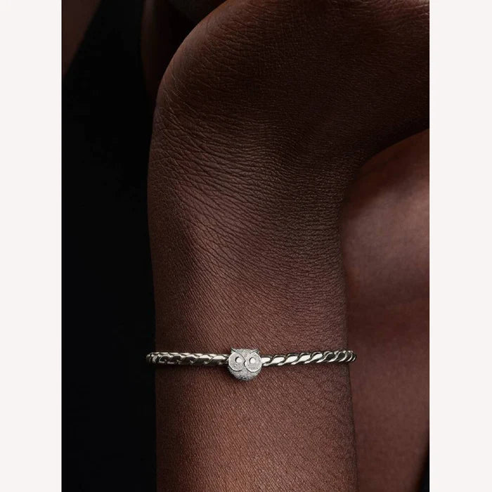 Silver bracelet with a small round clasp on a wrist