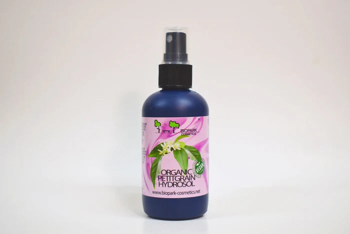 Bottle of organic facial toner with a pink label on a white background