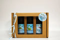 Three essential oil bottles in a cardboard gift box with a label on a light background