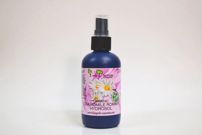 Bottle of organic chamomile Roman hydrosol with a spray nozzle on a white background