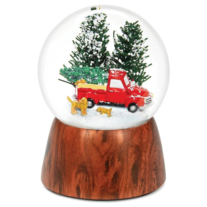 musical glitter dome featuring a red Christmas truck with adorable dogs in a festive snowy scene.