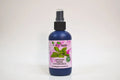 Bottle of organic sage hydrosol with a pink label on a white background