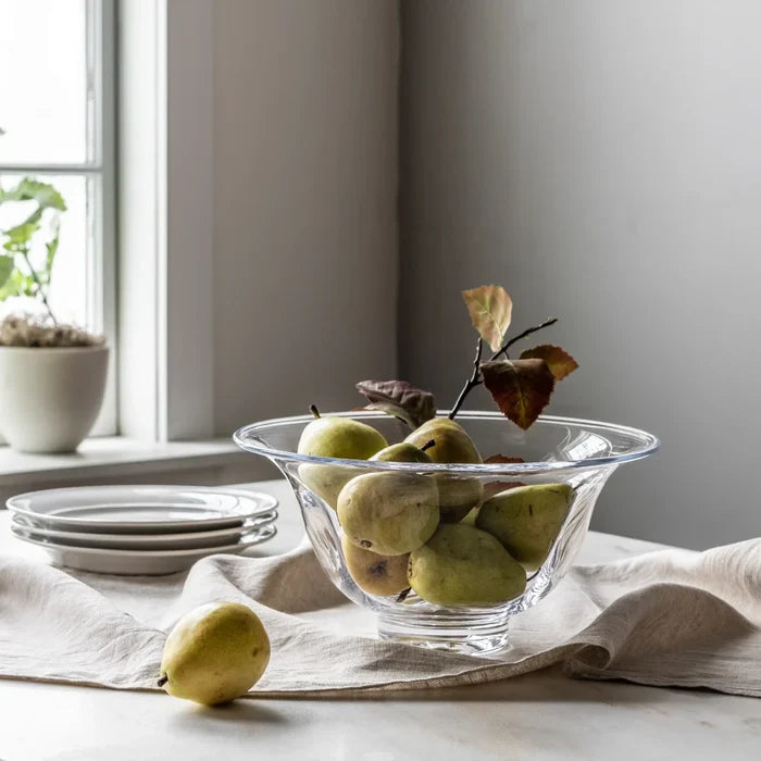 A vibrant bowl of mixed fruit, featuring oranges, bananas, and apples, displayed on a table.