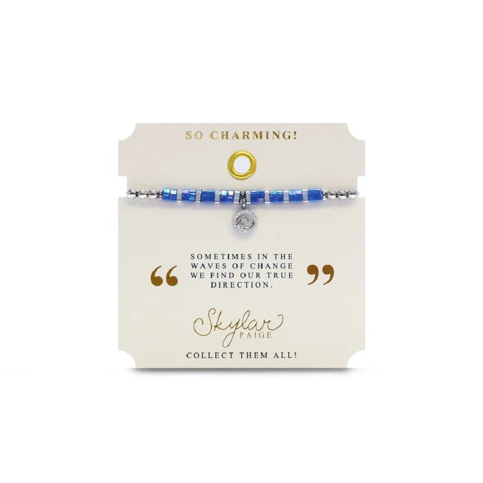 A bracelet with vibrant blue stones and a delicate silver charm, showcasing a blend of elegance and charm.