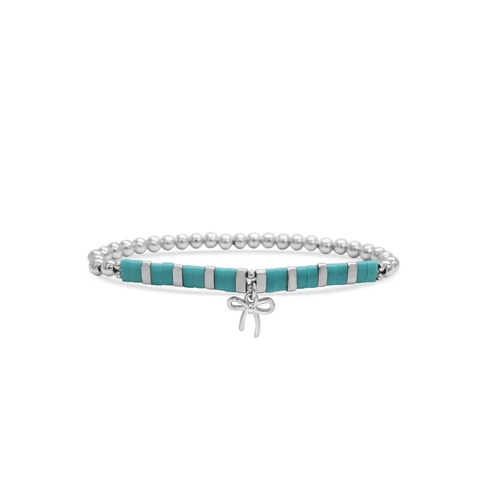 A turquoise bracelet adorned with a decorative bow, showcasing a stylish and playful design.