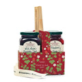 Stonewall Kitchen jam set with two jars and a wooden spreader in a decorative carrier on a white background.