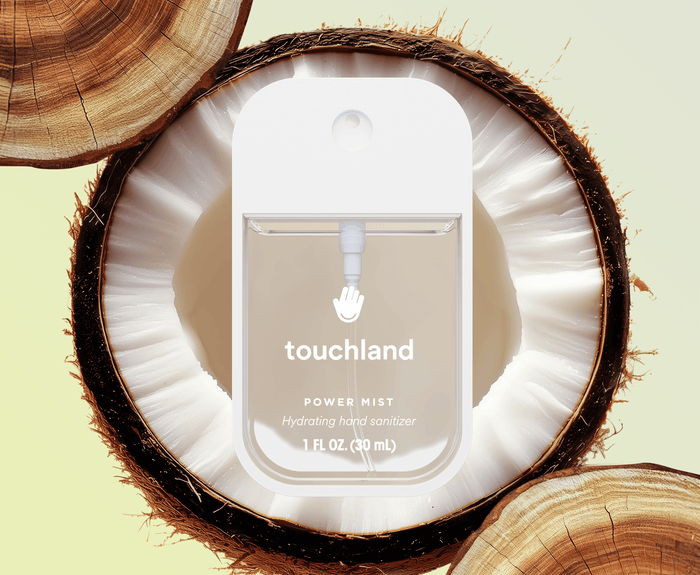Touchland power mist packaging inside a coconut shell on a light green background