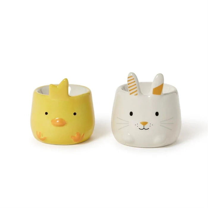 Two decorative ceramic eggs showcase a bunny and a chick inside, highlighting a charming springtime theme.