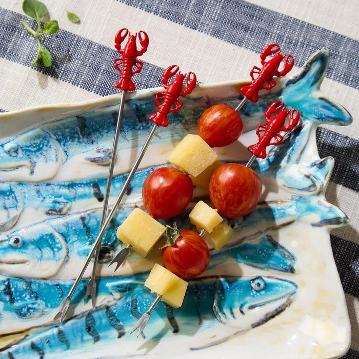 A serving plate with succulent lobster skewers and vibrant red tomatoes.