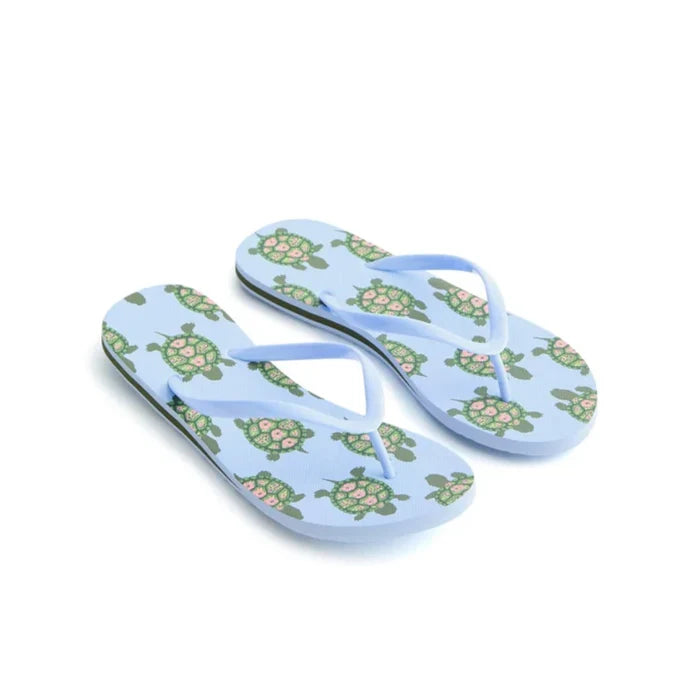 A pair of flip flops featuring turtle designs on the straps, set against a neutral background.