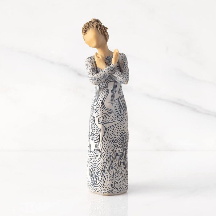 "Willow Tree Music Speaks figurine with lighter skin tone – hand-painted resin sculpture featuring musical instrument carvings and heart-holding pose"