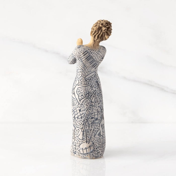 "Willow Tree Music Speaks figurine with lighter skin tone – hand-painted resin sculpture featuring musical instrument carvings and heart-holding pose"