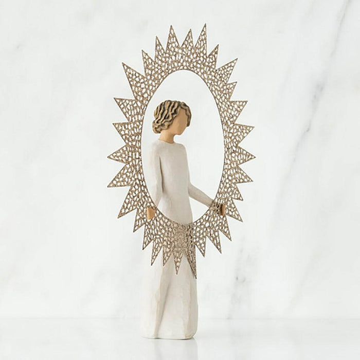 "Willow Tree Starlight Tree Topper figurine holding a starburst frame, standing atop a Christmas tree"