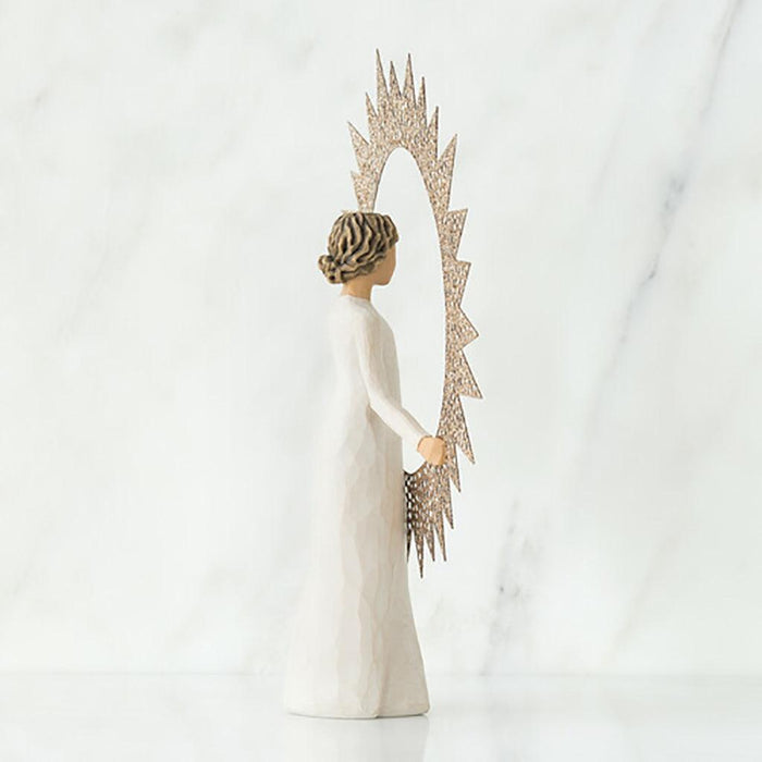 "Willow Tree Starlight Tree Topper figurine holding a starburst frame, standing atop a Christmas tree"