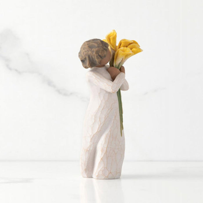 "Willow Tree With Gratitude figurine – hand-painted resin sculpture of a woman with darker skin tone holding a bouquet of yellow calla lilies in appreciation"
