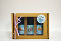 Set of three essential oil bottles in a cardboard gift box with a ribbon on a white background