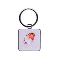 A square keychain featuring a colorful bird design on its surface.