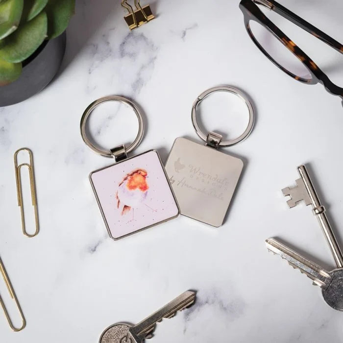 A square keychain displaying a bird motif in vibrant colors.